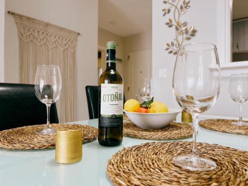 una bottiglia di vino appoggiata su un tavolo con dei bicchieri di Ulises La Perla a Calahonda