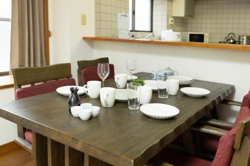 a wooden table with plates and wine glasses on it at 緑翠-Ryokusui- in Fukuoka