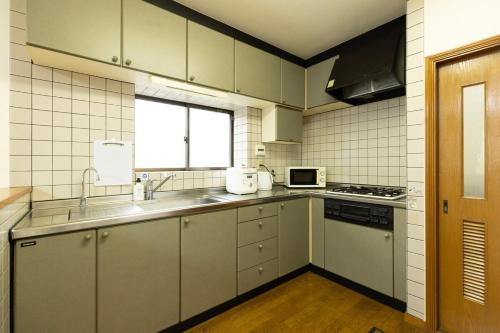 a kitchen with a sink and a stove top oven at 緑翠-Ryokusui- in Fukuoka