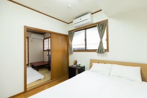 a bedroom with a bed and a window at 緑翠-Ryokusui- in Fukuoka
