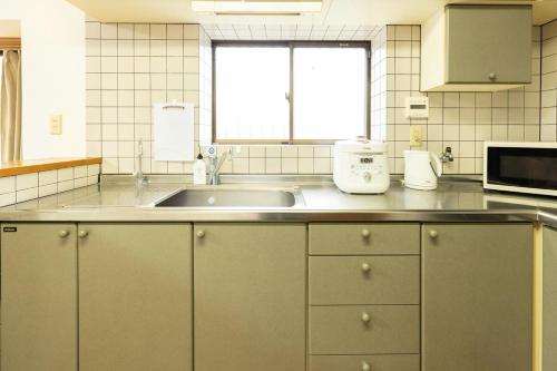 a kitchen with a sink and a window at 緑翠-Ryokusui- in Fukuoka