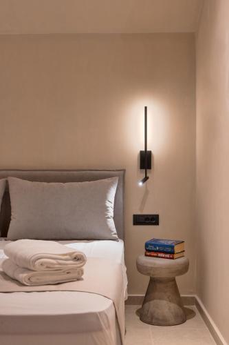 a bedroom with a bed with a stack of books at Ino Villas Kefalonia in Kefallonia