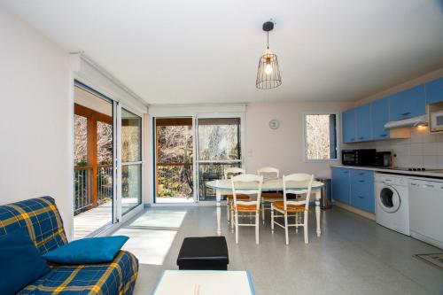 une cuisine et un salon avec une table et des chaises dans l'établissement La Genette - Vue montagne parking couvert, à Barèges