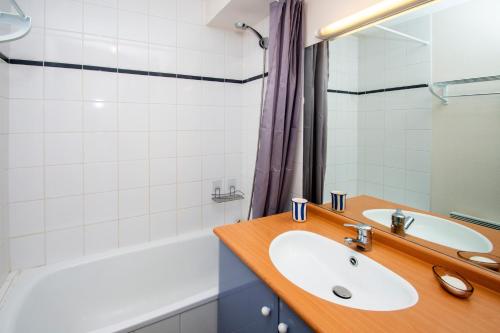 une salle de bain avec un lavabo et une baignoire dans l'établissement La Genette - Vue montagne parking couvert, à Barèges