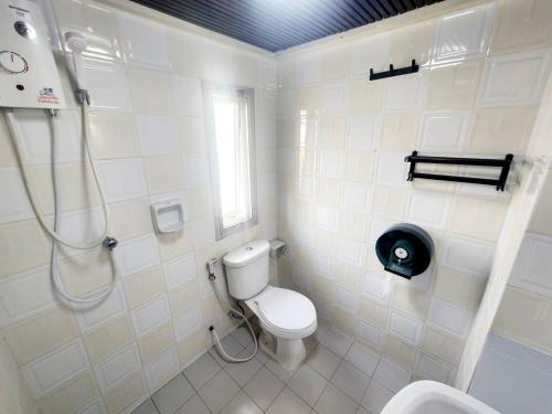 a white bathroom with a shower and a toilet at Khaosan Art Hotel in Bangkok