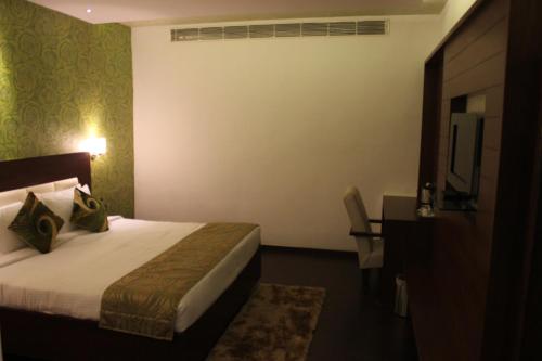 a hotel room with a bed and a desk at Tabla Pride Hotels & Spa in Hyderabad