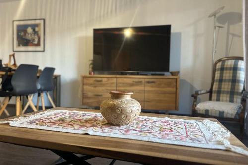 un vase assis sur une table devant une télévision dans l'établissement Vacances à Ajaccio Charmant T2 climatisé avec WIFI et parking, à Ajaccio