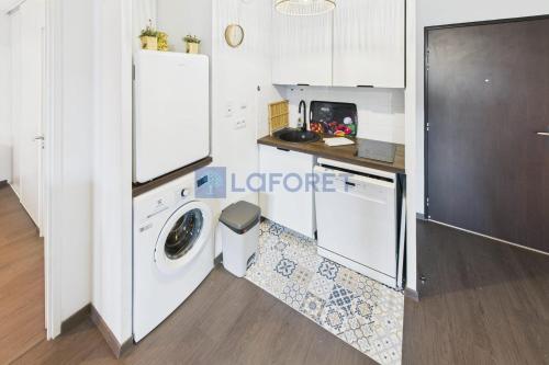 une cuisine avec un réfrigérateur et une machine à laver dans l'établissement Vacances à Ajaccio Charmant T2 climatisé avec WIFI et parking, à Ajaccio