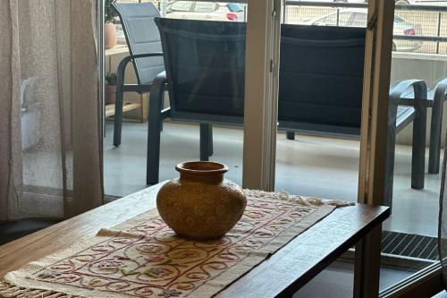 un vase assis au-dessus d'une table en bois dans l'établissement Vacances à Ajaccio Charmant T2 climatisé avec WIFI et parking, à Ajaccio