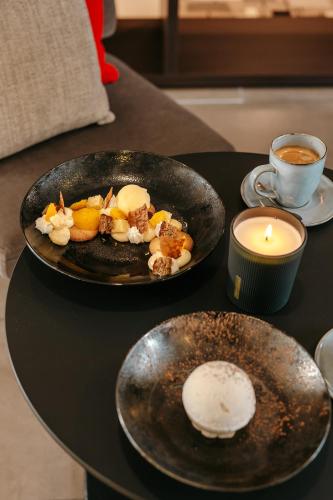 a table with two plates of food and a candle at Escale Oceania Brest in Gouesnou