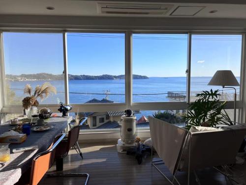 a dining room with a view of the ocean at 熱海 無二荘 絶景オーシャンビュー ピアノ Bbq 三階建て貸切宿 in Atami