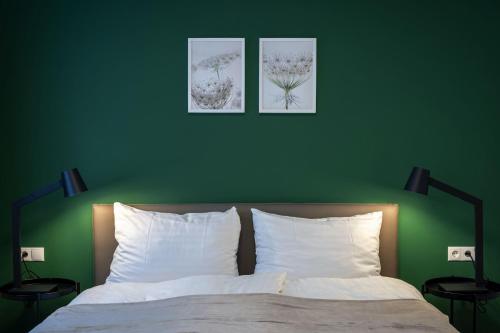 a bedroom with green walls and a bed with white pillows at City Appartement - Premium in Schwaz
