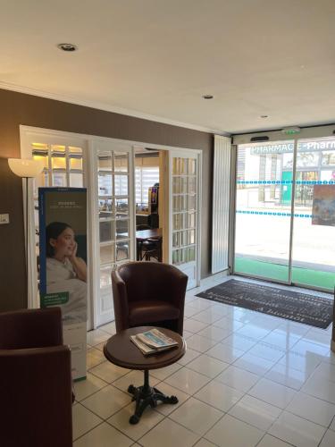 Una sala de estar con una silla y una ventana. en Brit Hotel Cherbourg, en Cherbourg-en-Cotentin