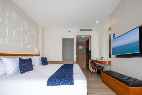 a hotel room with a bed and a flat screen tv at Sira Grande Hotel, Patong in Patong Beach