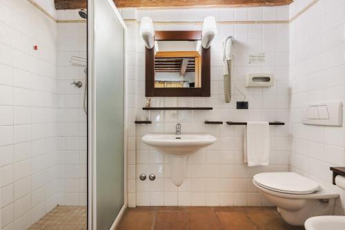 a white bathroom with a sink and a toilet at Hotel San Claudio in Corridonia