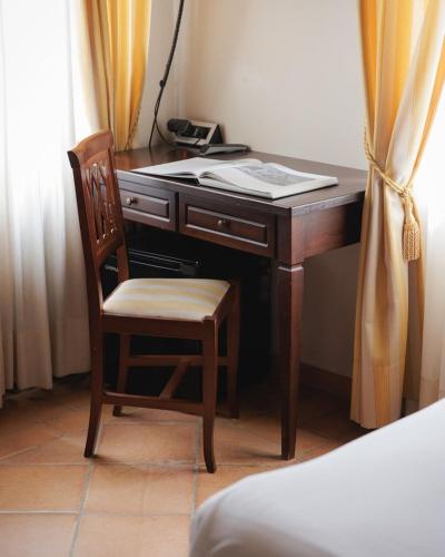 a wooden desk with a chair and a telephone at Hotel San Claudio in Corridonia