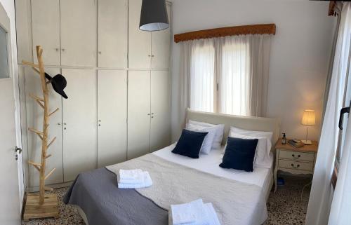 a bedroom with a bed with blue pillows at Calliope's house in Skiros