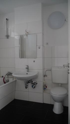 un bagno bianco con lavandino e WC di MK Apartment Delmenhorst 4 - Free Wifi - Free Parking - nähe HBF a Delmenhorst