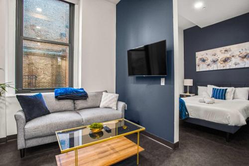 a living room with a couch and a bed at CozySuites Stunning 1BR in Downtown Pitts #21 in Pittsburgh
