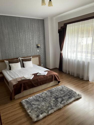 a bedroom with a bed with a rug and a window at Villa Prestige in Sovata