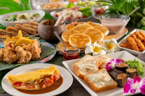 a table topped with plates of food and appetizers at Spa Resort Hawaiians Monolith Tower in Iwaki