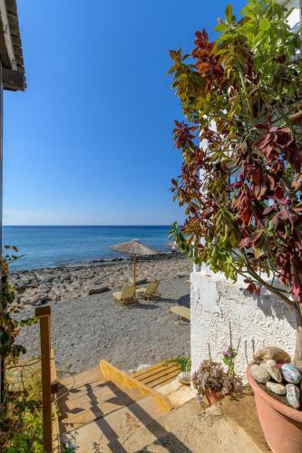 a beach with an umbrella and chairs and the ocean at VistaMare2 Double room-sea view in Koutsourás