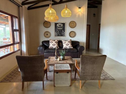a living room with a couch and a table and chairs at Ndefu Self Catering Accommodation in Otjiwarongo