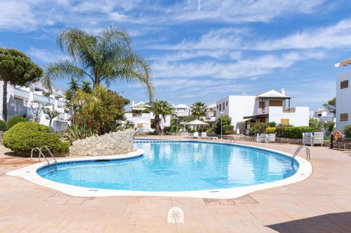 a swimming pool in the middle of a resort at Mediterranean Way - Punta Prima in La Pineda