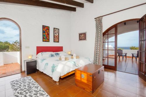 una camera da letto con un letto e vista sull'oceano di Cavall Menor a Cala Morell