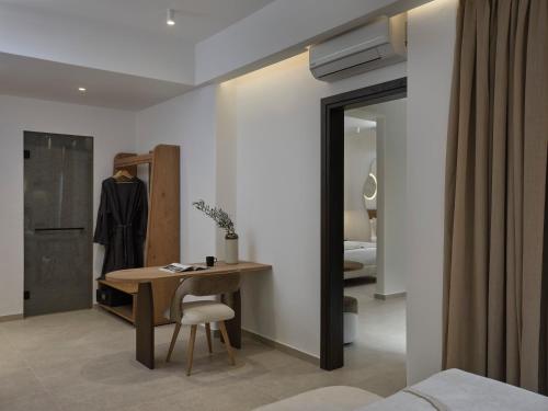 a bedroom with a table and a bedroom with a bed at Iria Blue Mykonos in Platis Yialos Mykonos