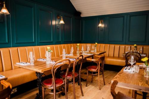 a row of tables in a restaurant with green walls at Corner House Canterbury in Canterbury