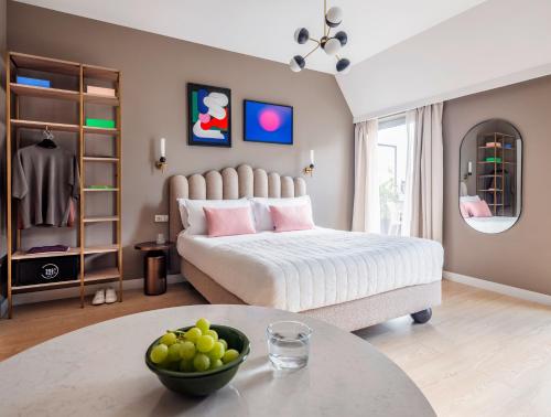 a bedroom with a bed and a table with a bowl of fruit at Numa Lisbon Rato in Lisbon