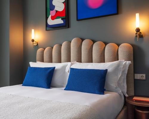 a bedroom with a large bed with blue pillows at Numa Lisbon Rato in Lisbon