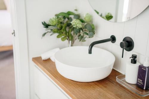 a bathroom with a white sink and a mirror at Tree Top Treasure Itas in Kings Meadows