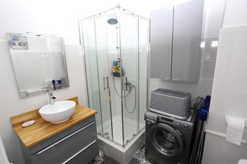 une salle de bain avec douche et machine à laver dans l'établissement Appartement T2 à 2 pas de la mer de St Cyprien, à Saint-Cyprien