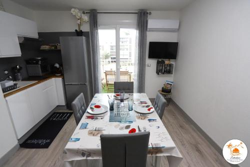 une cuisine avec une table et des chaises dans une pièce dans l'établissement Appartement T2 à 2 pas de la mer de St Cyprien, à Saint-Cyprien