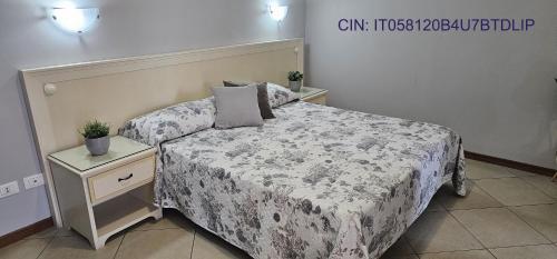 a bedroom with a bed and a nightstand with a bed sidx sidx sidx sidx at Fiumicino Inn Airport in Fiumicino