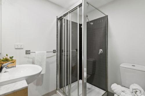 a bathroom with a shower and a toilet and a sink at Chic 2BR Loft Near Melbourne Central Free Parking in Melbourne