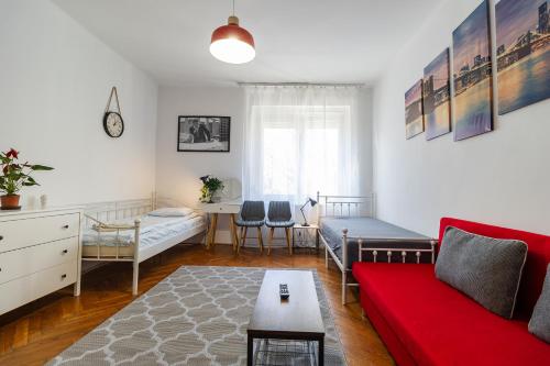un soggiorno con un divano rosso e un tavolo di LénApartman - Brooklyn a Pécs