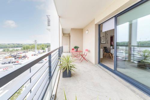 un balcon avec vue sur un parking dans l'établissement L'Aragon Wifi Balcon vue La Maine, à Angers