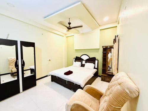 a bedroom with a bed and a couch at Vrindas Home Stay in Maheshwar