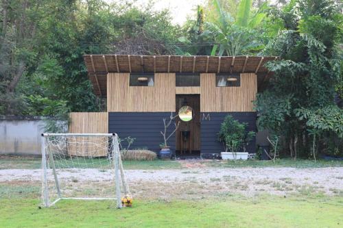 a house with a soccer goal in front of it at Kaitoon's River House in Ratchaburi
