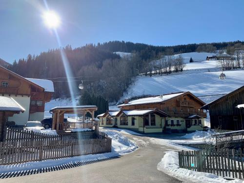 a snow covered village with houses and a fence at Heisshof in Schladming
