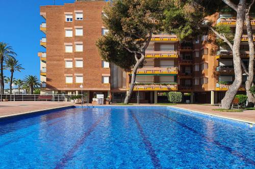 a large swimming pool in front of a building at AT139 Els Pins, 1ra línea de la playa, piscina, airco, in Torredembarra