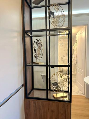 une caisse d'affichage en verre comportant des plaques dans l'établissement Stylish flat 1BR with terrace, park & pool, à Roquebrune-Cap-Martin