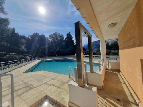 une maison avec une piscine sur un balcon dans l'établissement Stylish flat 1BR with terrace, park & pool, à Roquebrune-Cap-Martin
