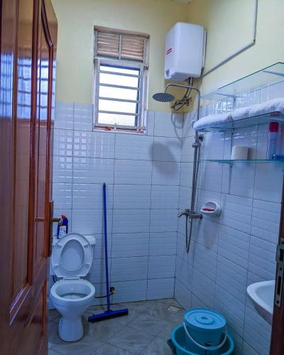 un baño con inodoro y lavabo en Monalisa Homes, en Kampala