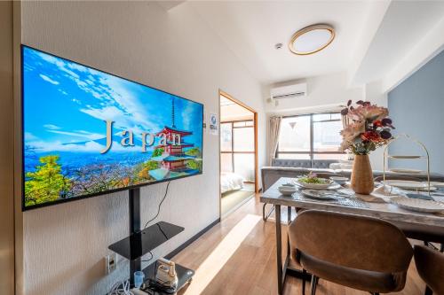 a living room with a large flat screen tv on a wall at Newly opened Hotel 3 京セラドーム徒歩10分 道頓堀 関西空港 大阪城 海遊館直行 USJ1回乗換 出張 Family friendly Free parking 15 minutes by car to USJ in Osaka
