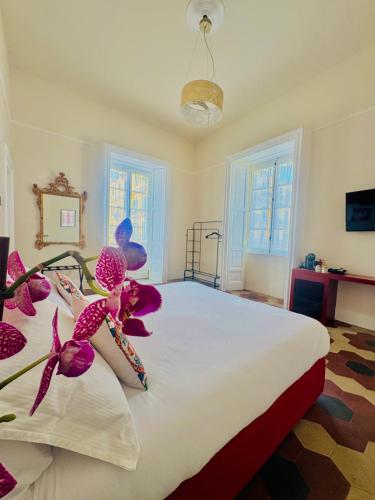 a bedroom with a large bed with purple flowers on it at Voglia 'e turnà in Naples