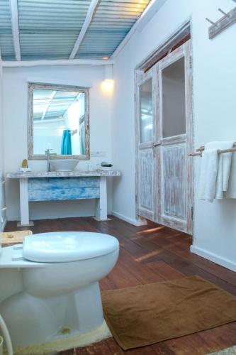 a bathroom with a toilet and a sink and a mirror at Trikora Beach Club and Resort in Telukbakau